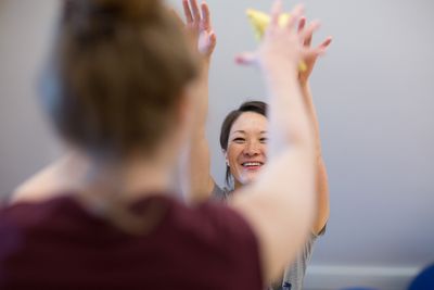 Bewegungstherapie Die Therapeutin lächelt die Patientin an