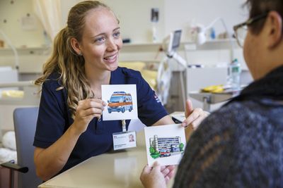 Therapie in der Logopädie Eine Logopädin zeigt der Patientin Bilder