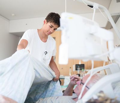 Pflege Ein Fachmann Gesundheit deckt einen Patienten zu