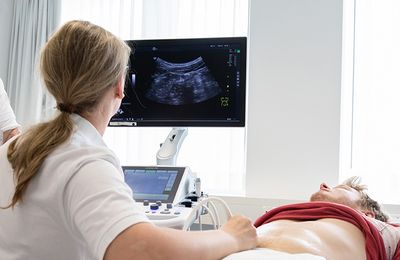 Untersuchung Zwei Ärztinnen untersuchen einen Patienten