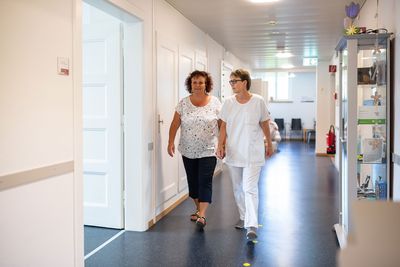 Spitalgang Eine Patientin und eine Mitarbeiterin gehen den Gang entlang