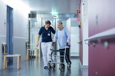Kompetent begleitet Eine Therapeutin begleitet eine ältere Patientin