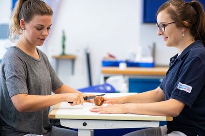 An einem Apfel üben Die Patientin schneidet einen Apfel