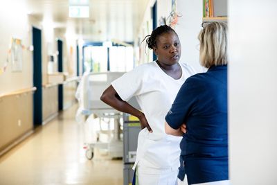 Gespräch zwischen zwei Mitarbeiterinnen Zwei Mitarbeiterinnen besprechen sich