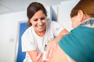 Eine Fachexpertin Hygiene impft eine Frau