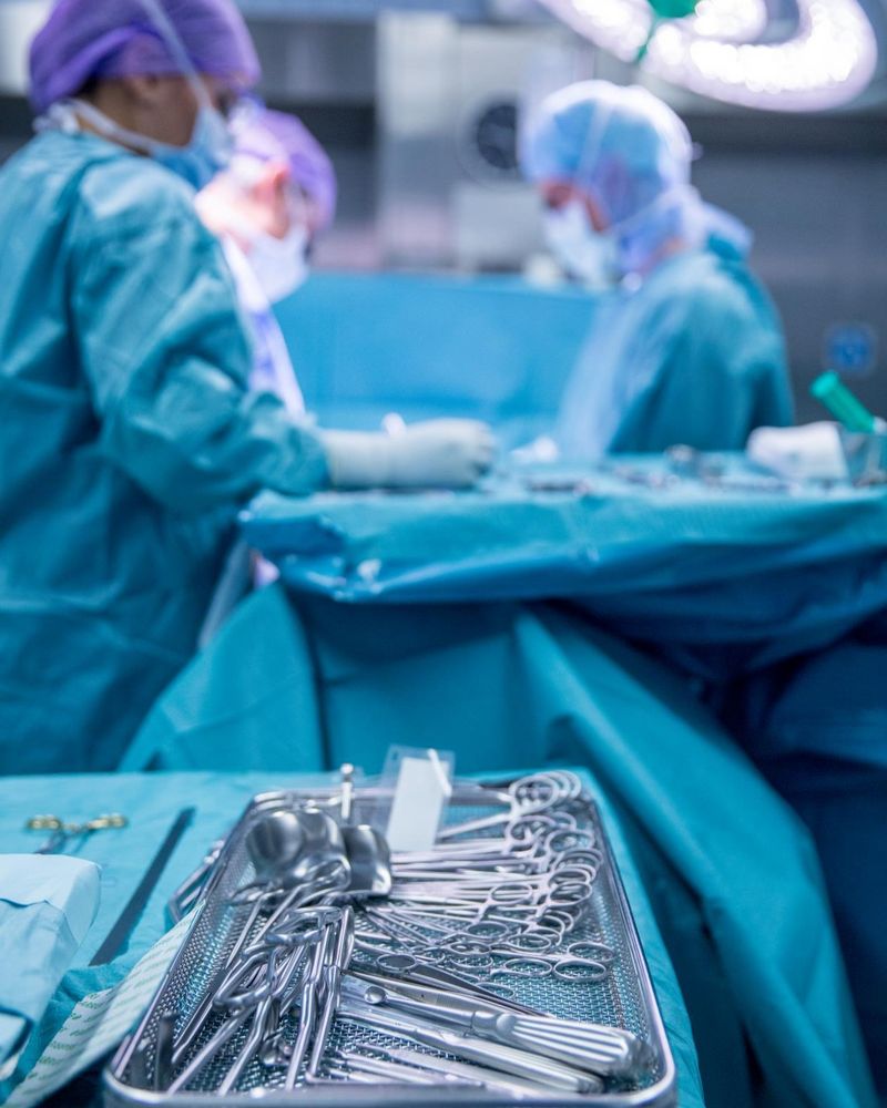 Fachkraft in der AEMP bei der Arbeit mit Sterilisationsgeräten