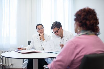 Bariatrische Sprechstunde Zwei Ärzte hören einer Patientin aufmerksam zu