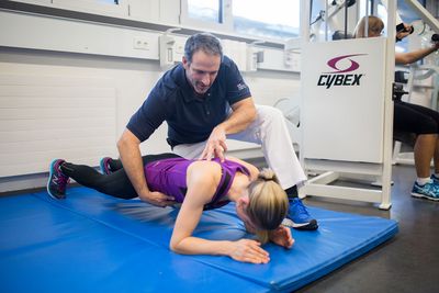 Fitness verbessern Der Physiotherapeut hilft einer Frau bei ihrem Training