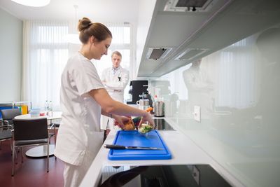 Ernährungsberatung Die Ernährungsberaterin bereitet ein Gericht zu