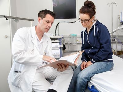 Pneumologische Sprechstunde Der Pneumologe zeigt der Patientin die Untersuchungsergebnisse