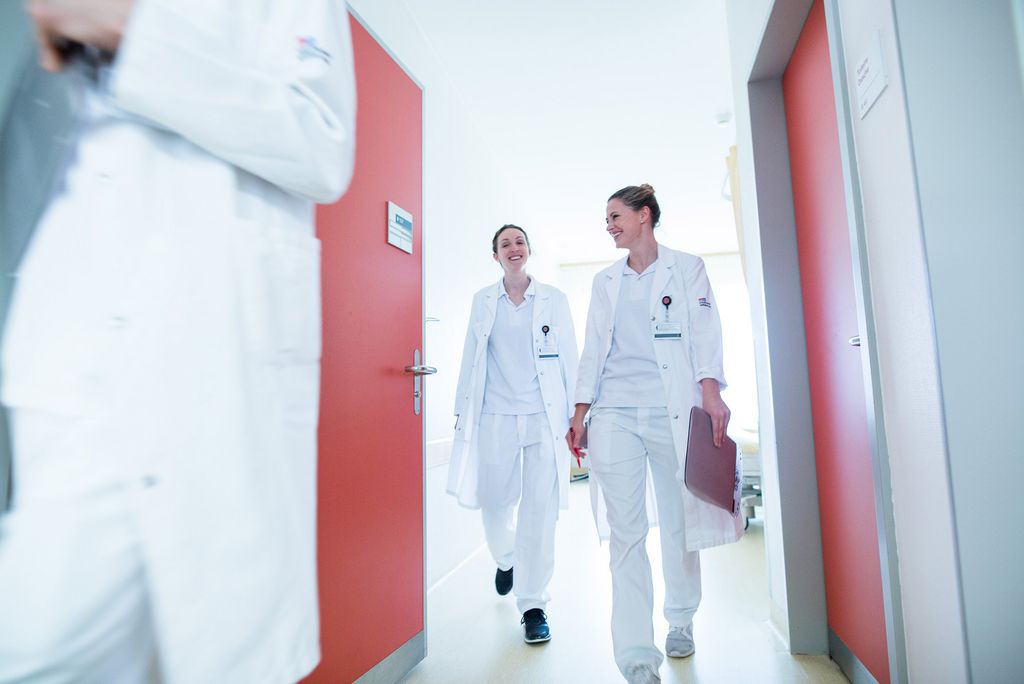 Zwei Ärztinnen verlassen ein Patientenzimmer
