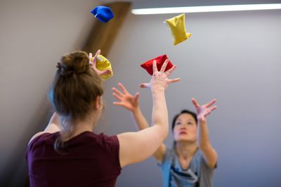 Bewegungstherapie Zwei Frauen werfen Bälle in die Luft