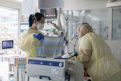 Teamarbeit in der Intensivstation Zwei Pflegerinnen kümmern sich um einen Patienten