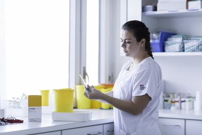 Hilfsmittel Eine Mitarbeiterin kontrolliert Medikamente