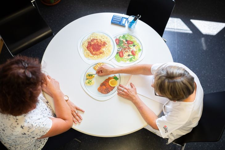 Ernährungsberaterin am Tisch mit Patientin